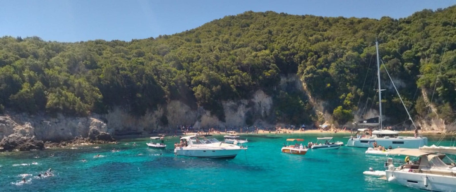 Boats gathered in an emerald bay near Sivota